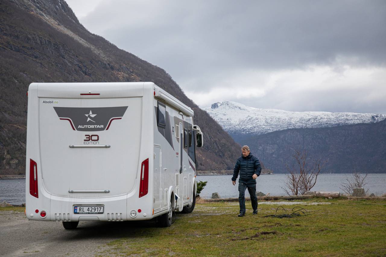 Erling Svensen utenfor bobilen parkert ved sjøen