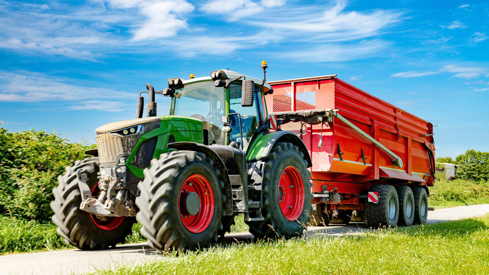Stor grønn traktor med tilhenger (ill.foto)