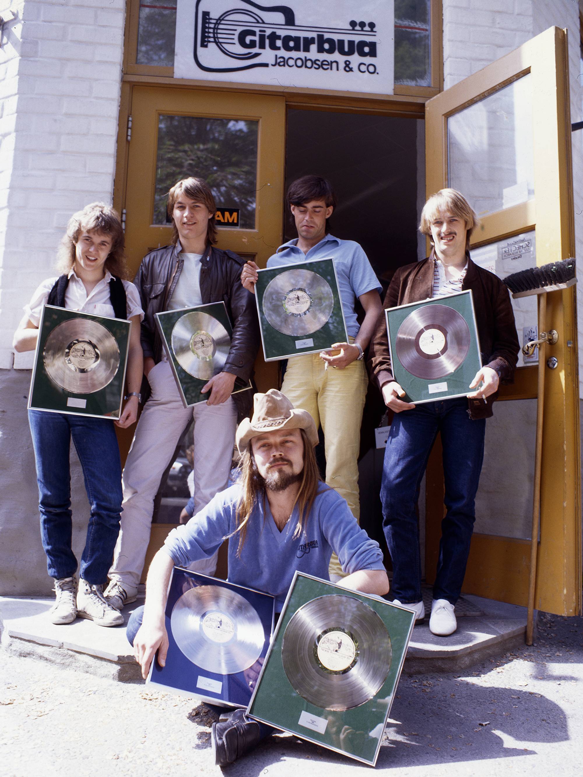 Terje Tysland sammen med bandet The Game med gullplate. 
