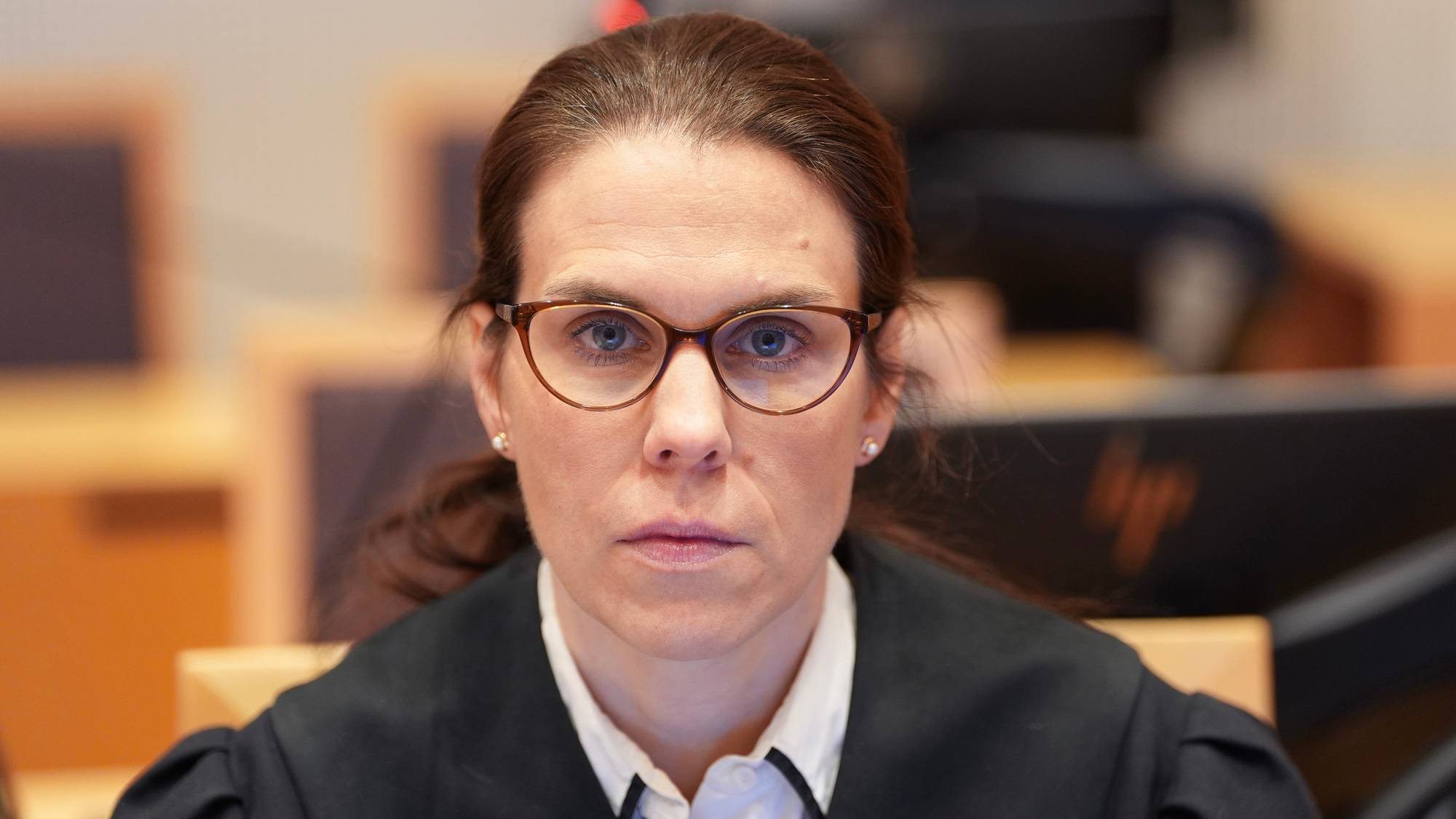 viser en dame med skjorte og brunt hår og briller