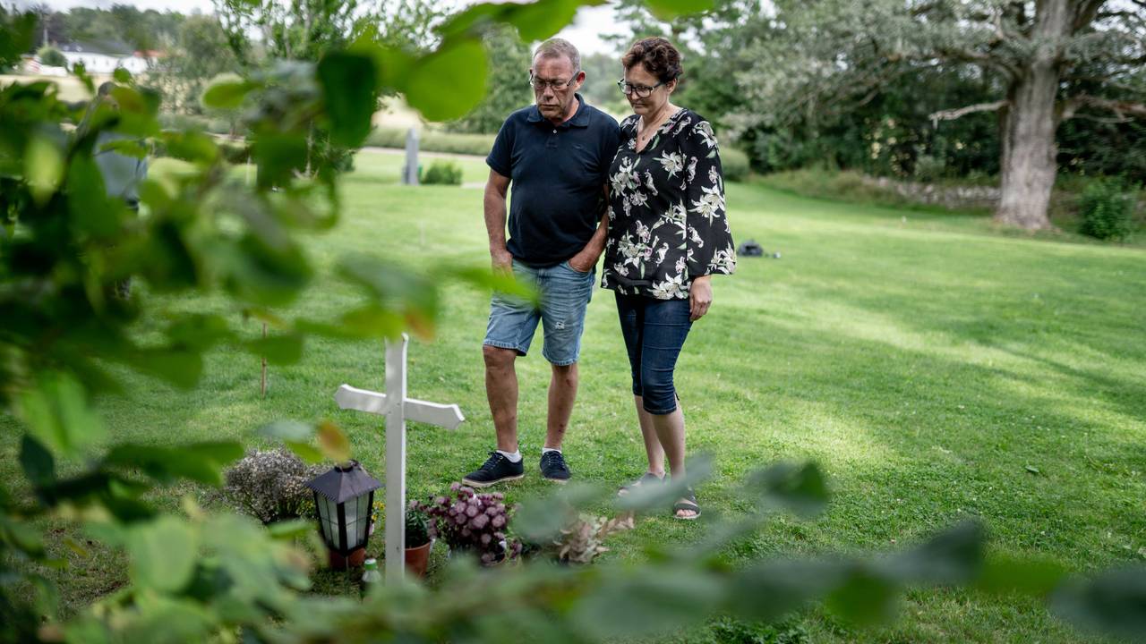 Bilde av foreldrene til Cecilie som står foran graven hennes. De har en alvorlig mine over seg.