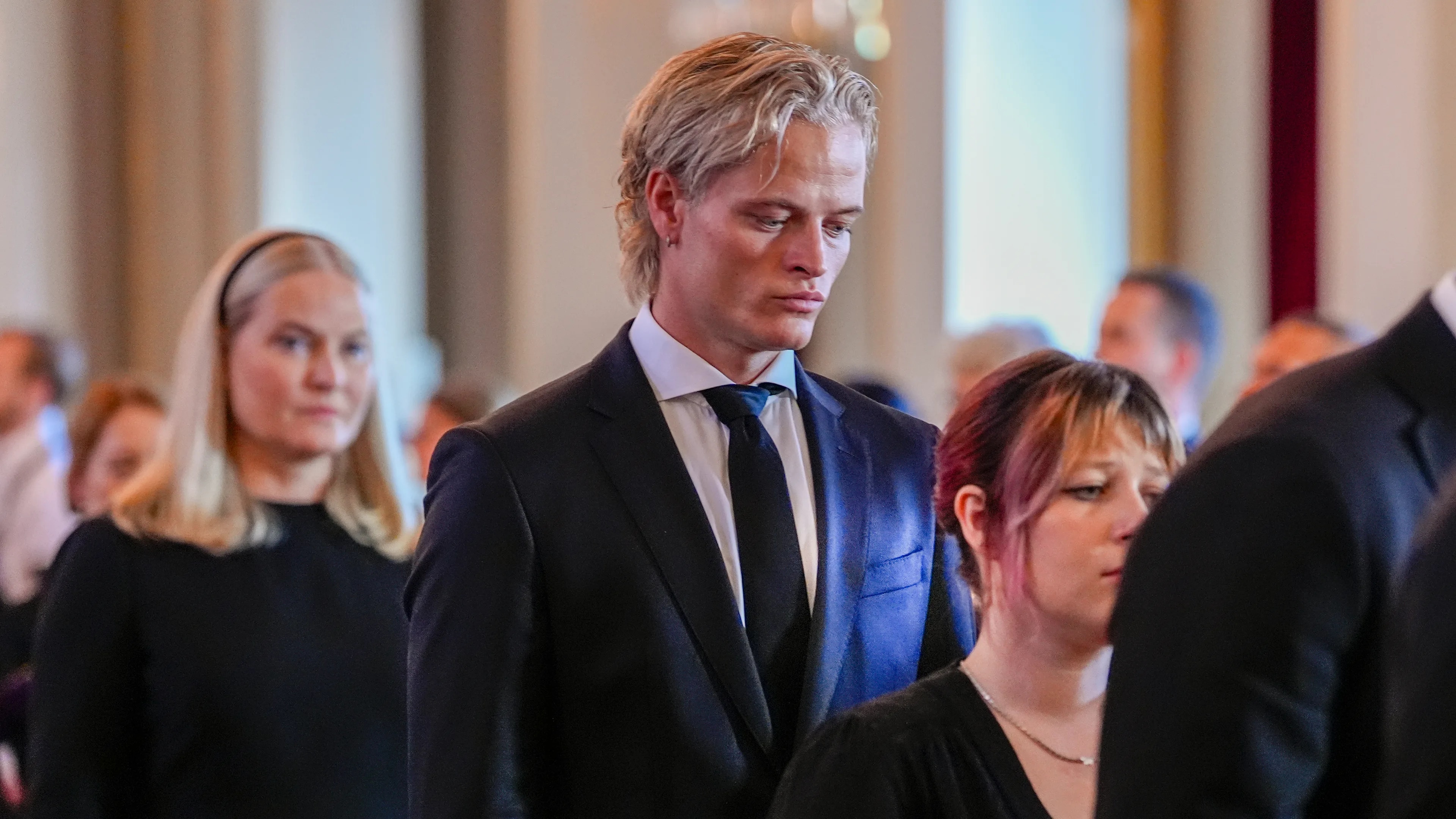 Kong Harald Vs båre flyttes fra den Røde salong til Slottskapellet mandag. Båren ledsages av kong Haralds familie og ansatte ved hoffet gjennom de historiske salene på Slottet. Prinsesse Mrtha Louise og barnebarna kronprinsesse Ingrid Alexandra, prins Sverre Magnus, Marius Borg Høiby, Maud Angelica Behn, Leah Isadora Behn og Emma Tallulah Behn i Speilsalen. Dronning Mette-Marit og dronning Sonja er også med i prosesjonen. rikssverdet og kongens ordener. Barna, kong Haakon, prinsesse Mrtha Louise, barnebarna kronprinsesse Ingrid Alexandra, prins Sverre Magnus, Marius Borg Høiby, Maud Angelica Behn, Leah Isadora Behn og Emma Tallulah Behn i Speilsalen. Dronning Mette-Marit og dronning Sonja er også med i prosesjonen.