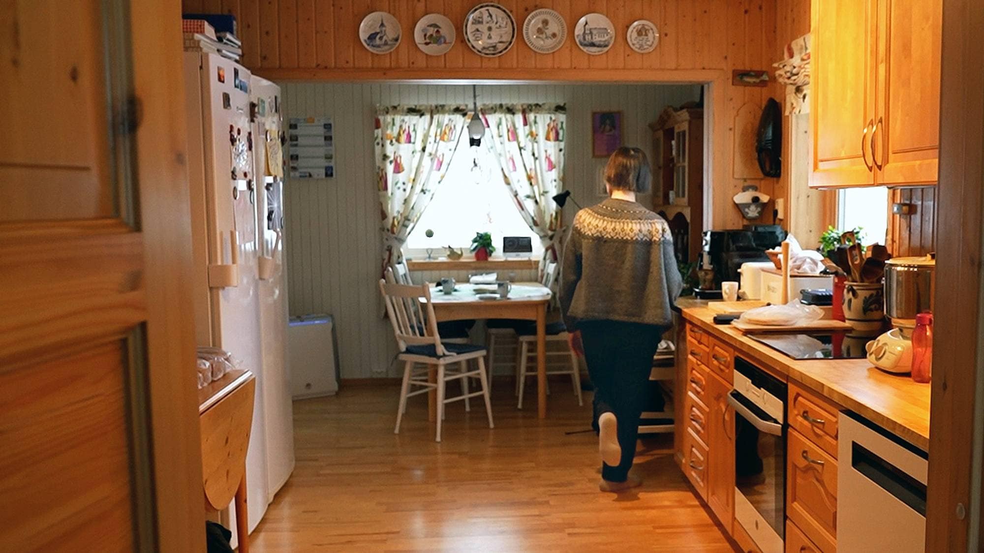 Jenny Margrethe Pedersen står på en fot hjemme på kjøkkenet.