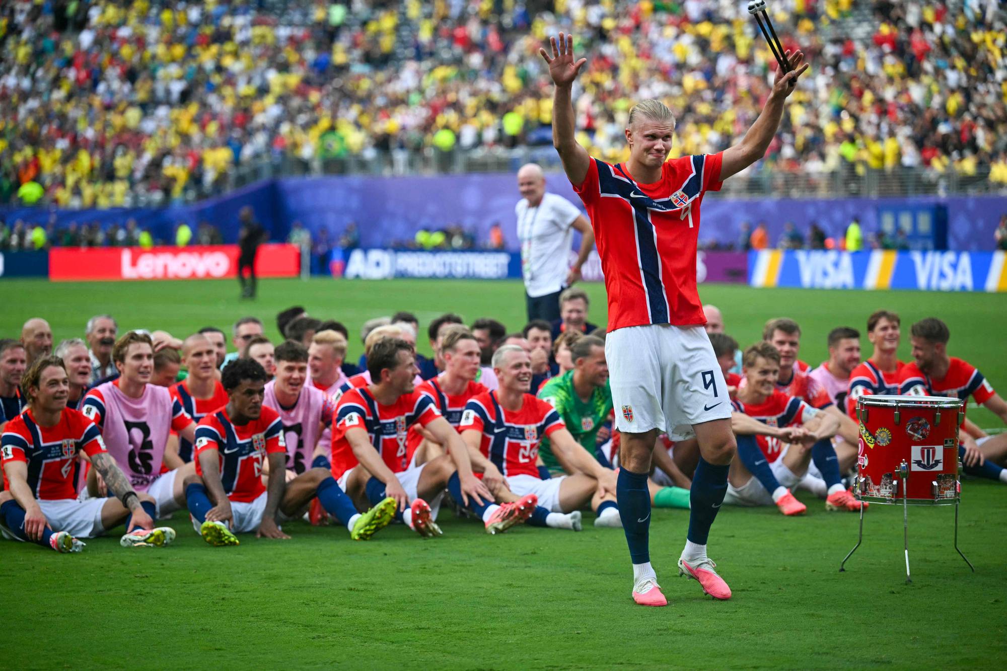 Erling Braut Haaland feirer med det norske landslaget på en fotballbane foran publikum. (Bildebeskrivelsen er laget av en KI-tjeneste)
