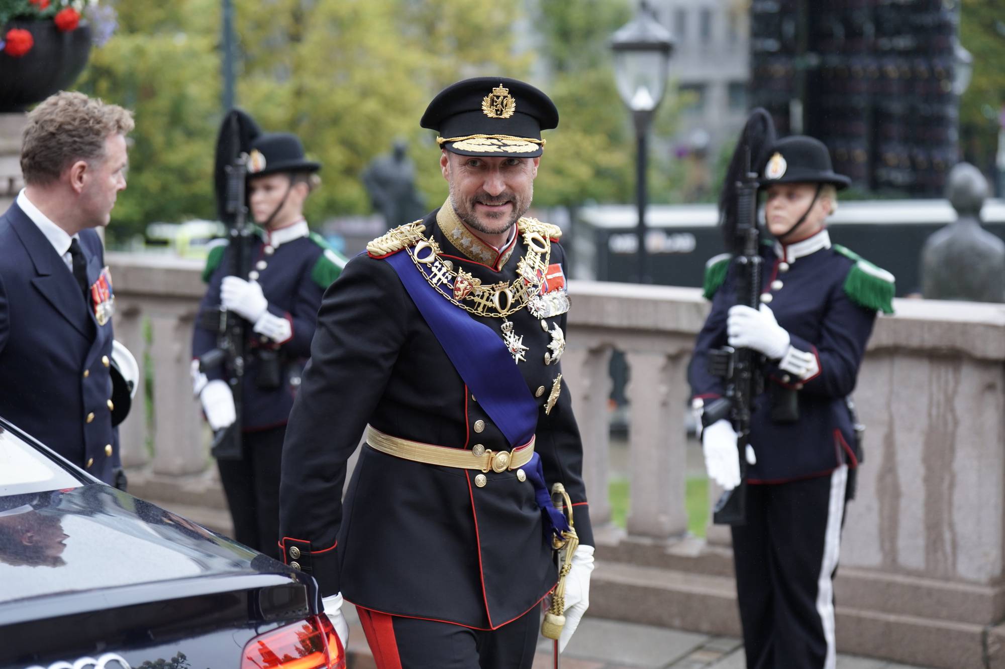 Kong Haakon ankommer Stortinget i uniform for å foreta den høytidelige åpningen av Stortinget