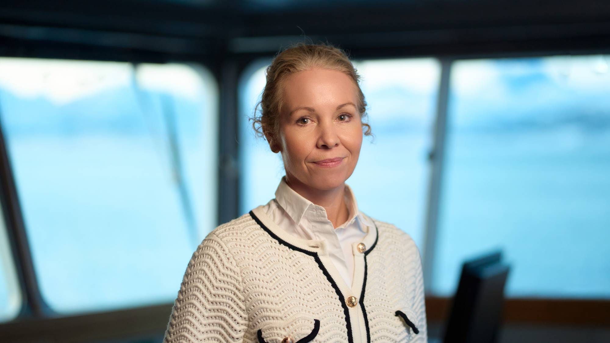 Konserndirektør i Hurtigruten Hedda Felin står på broa og ser i kamera