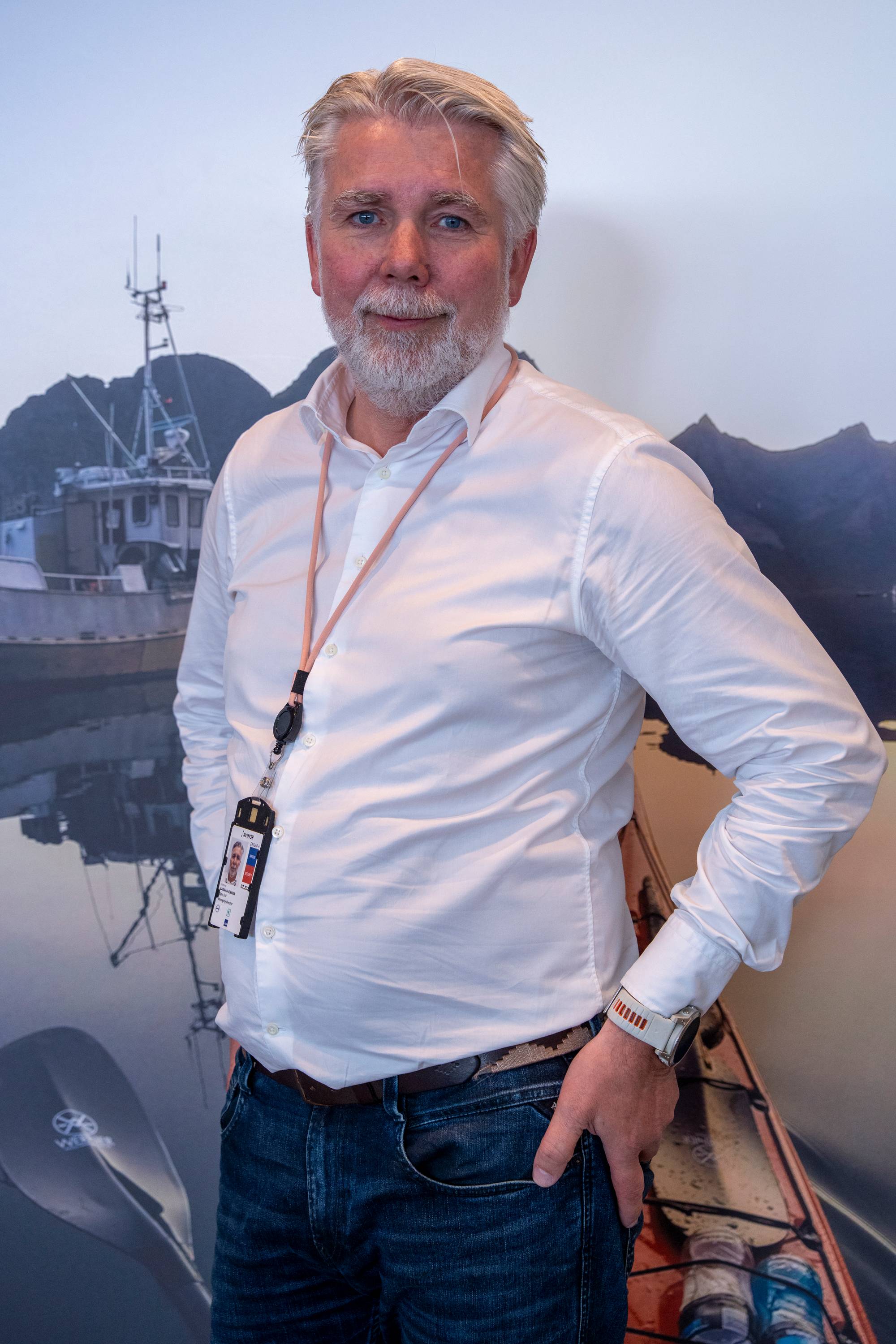 En mann med hvit skjorte og blå jeans 