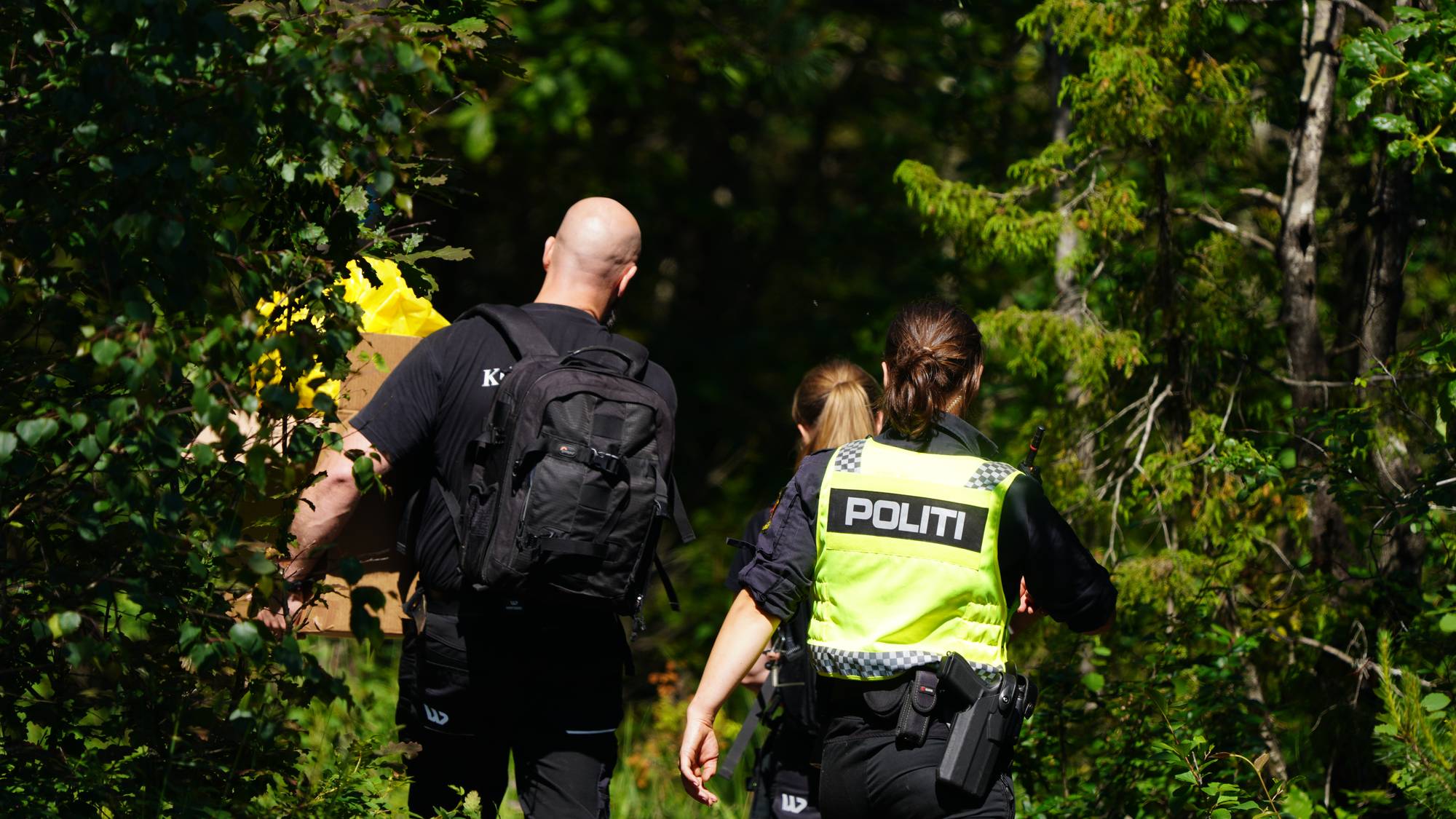 Uniformerte politifolk er på vei inn i en skog.