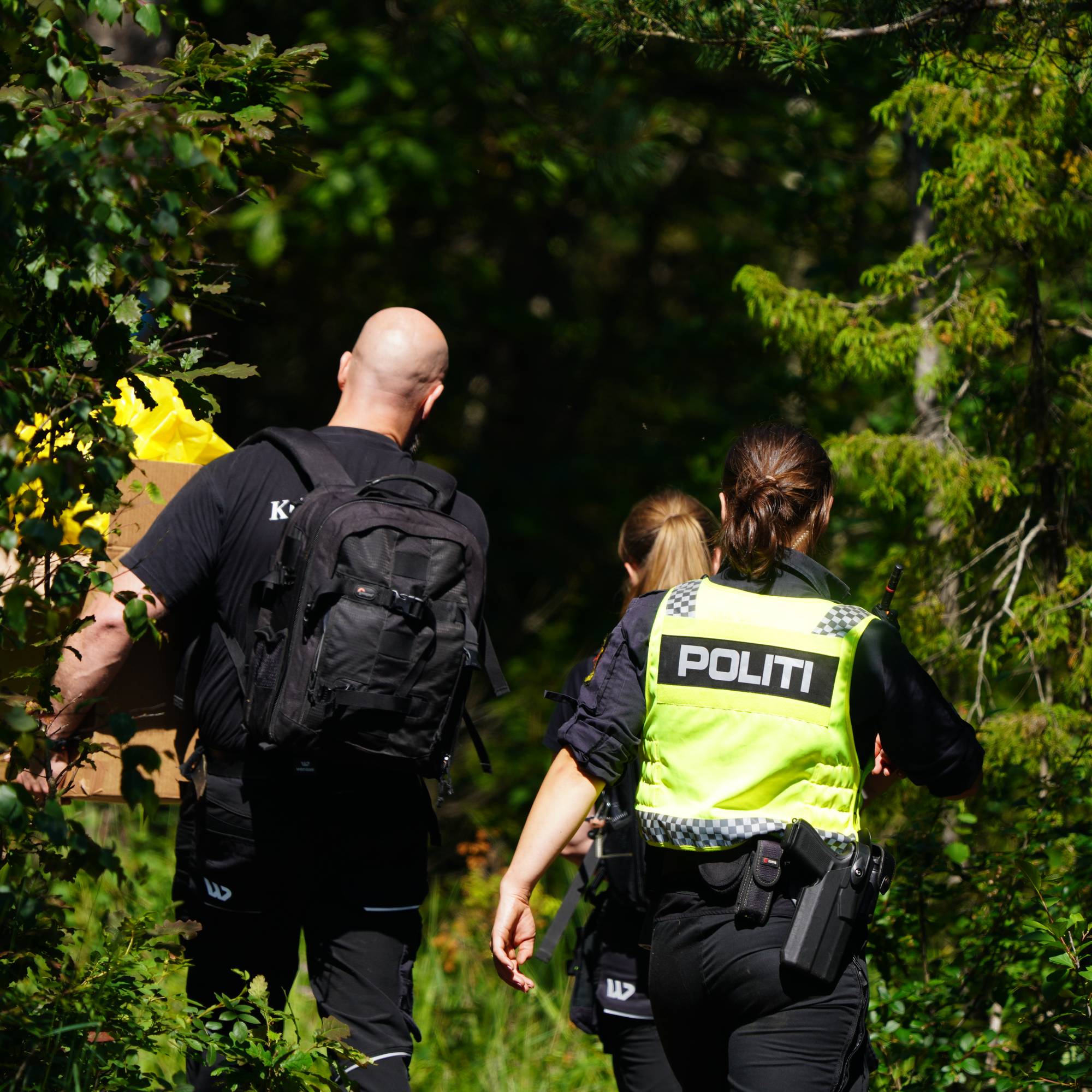 Uniformerte politifolk er på vei inn i en skog.