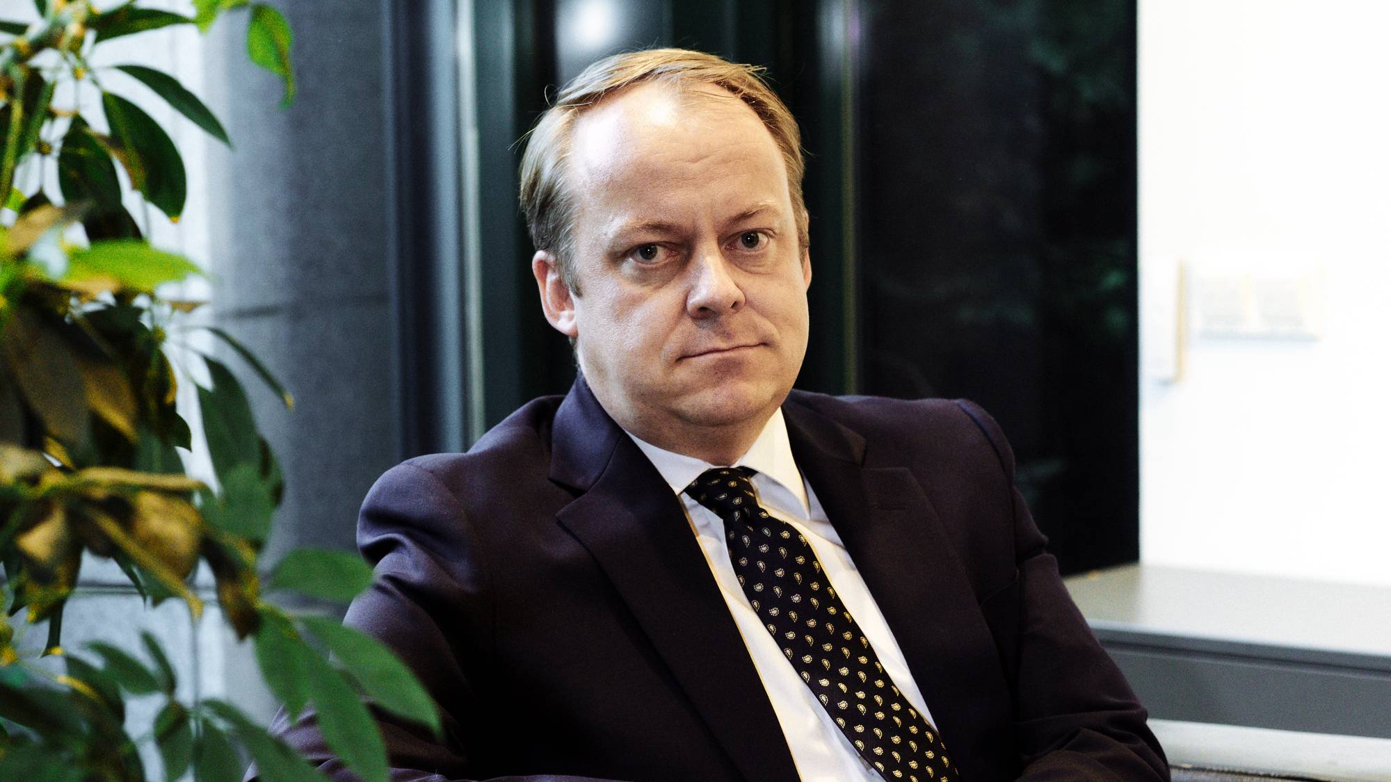 Mann sit i ein svart stol og ser mot kamera