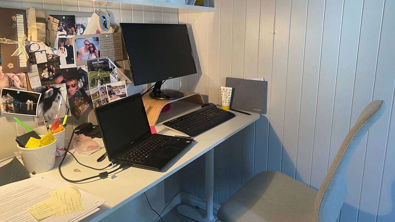 Et hjemmekontor i en krok. Fullt av bilder, tastatur, to skjermer