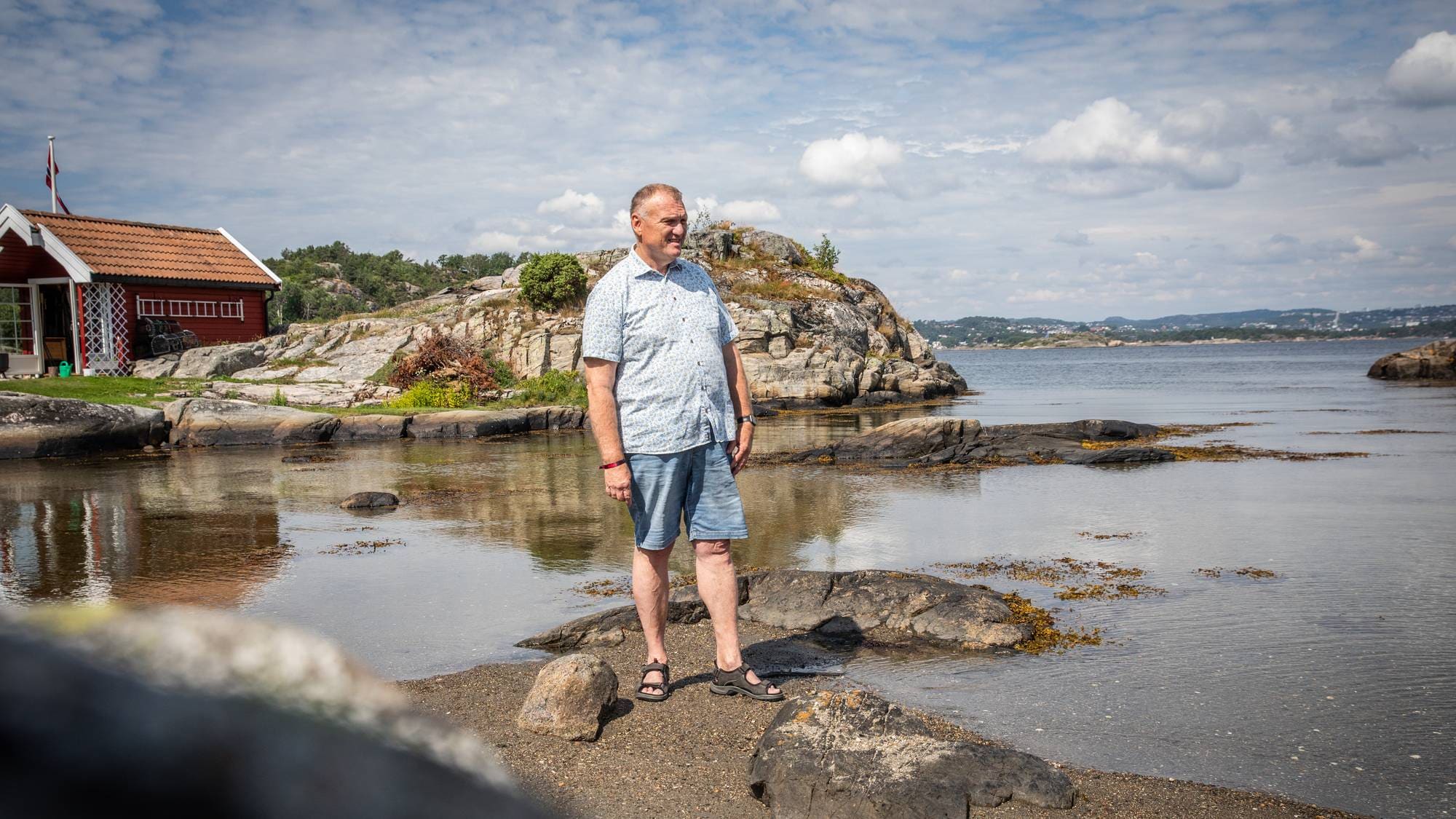 En mann som står på en stein i vannet