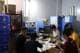 Go Nakamura / REUTERS,NTB En gruppe arbeidere sitter rundt et bord med maskiner bak seg