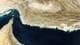 Foto: - / NASA Earth Observatory,NTB Satellittbilde viser et ørkenlandskap langs kysten av Den arabiske gulf. Mørkeblått vann møter tørre, beige landmasser. Flere øyer er synlige i det grunne, turkise vannet langs kysten. Bildet viser et stort, mørkt vannområde. (Bildebeskrivelsen er laget av en KI-tjeneste)
