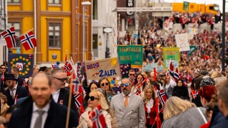 en folkemengde som går nedover en gate med flagg