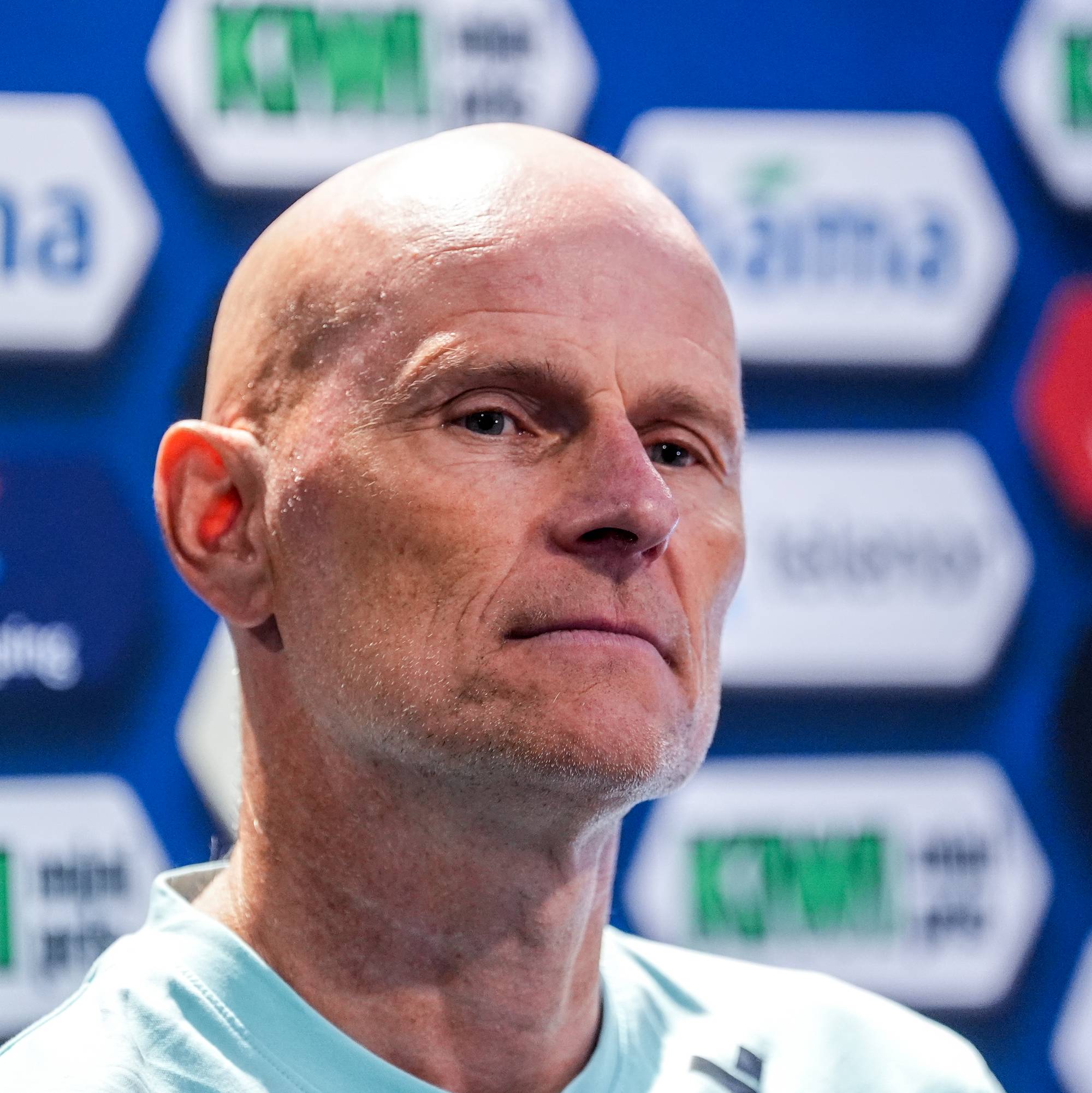 Ståle Solbakken foran en pressevegg med sponsorer. (Bildebeskrivelsen er laget av en KI-tjeneste)