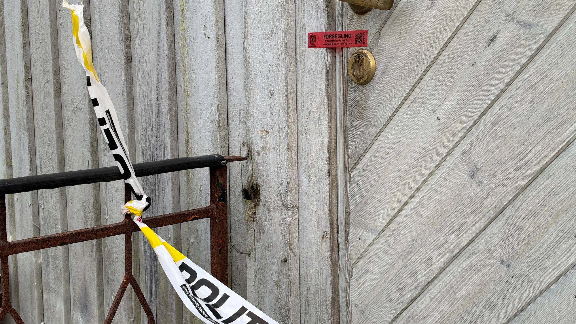 En slitt dør med politi teip hengende foran.