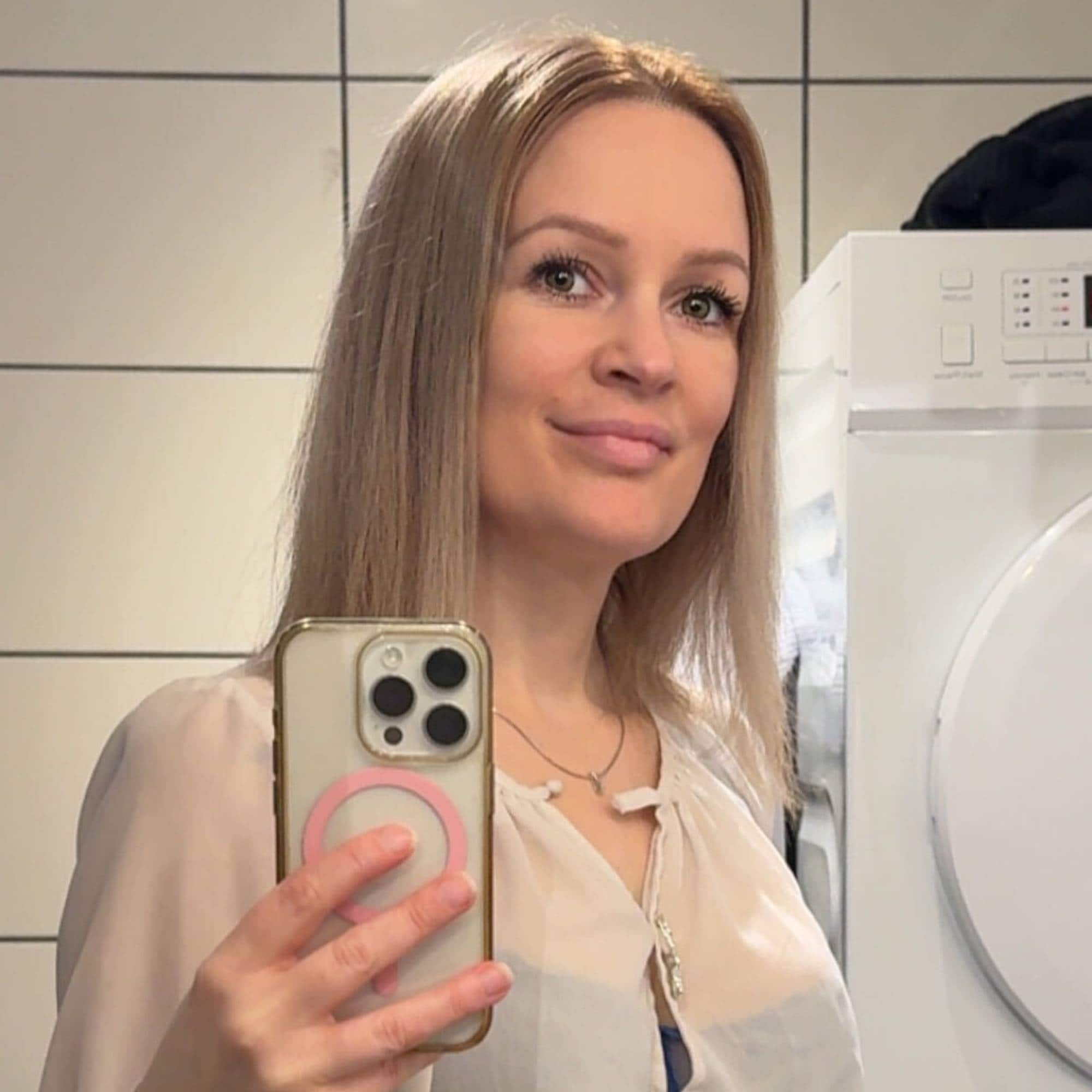 Kvinne som tar selfie i speilet. 