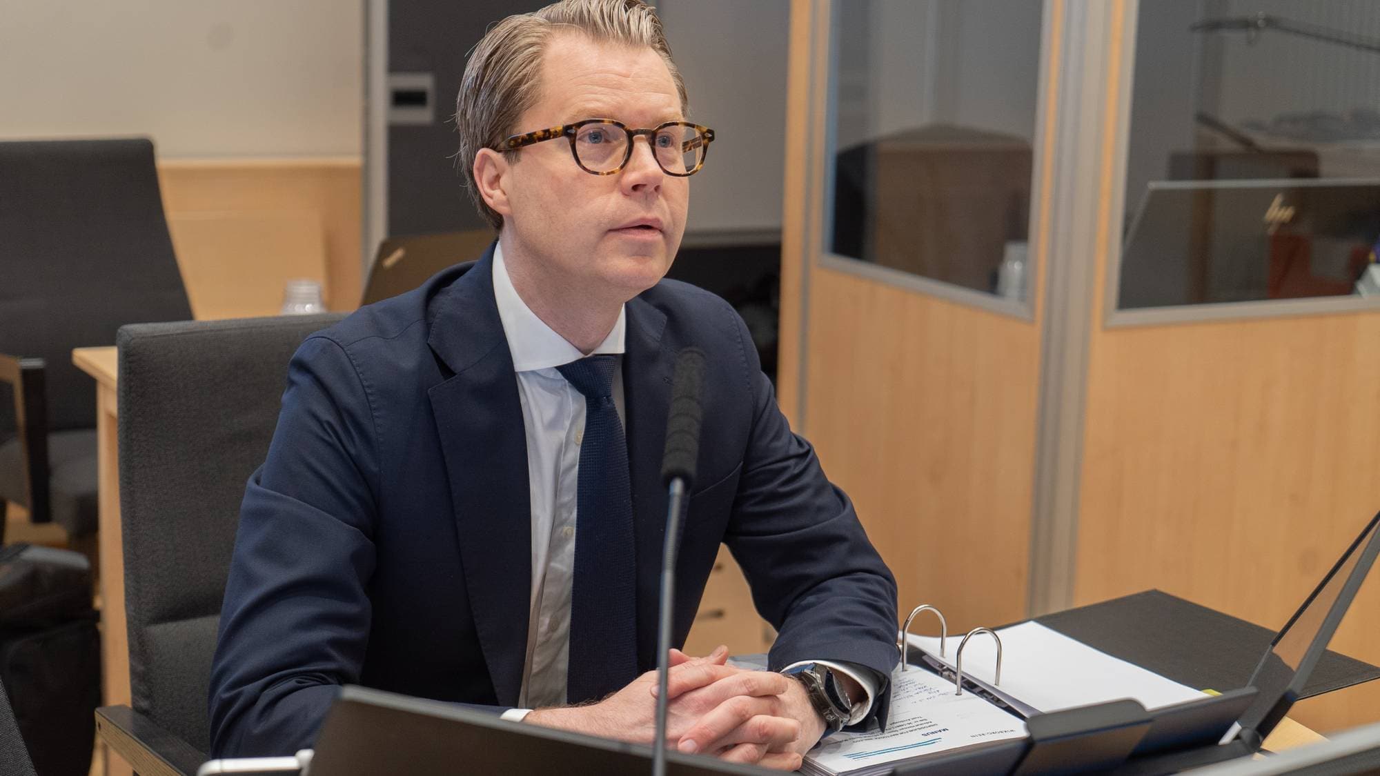 En advokat sitter i en rettssal og gjør klar pc og papir.