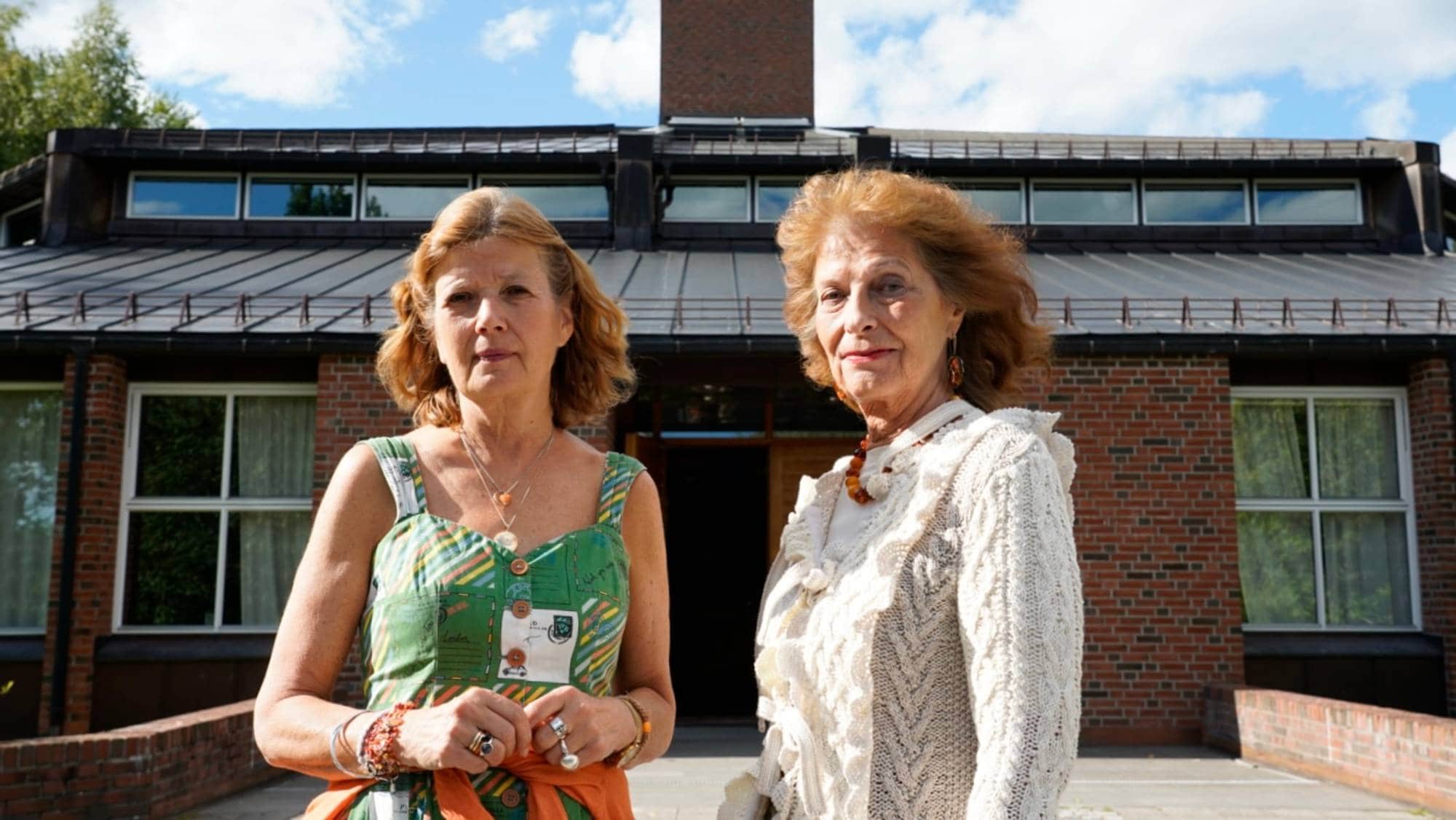 to kvinner står foran en kirke og ser inn i kamera