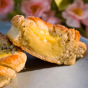 Vaniljebolle, med kardemomme og vaniljekrem ligger oppskjært på et fat.