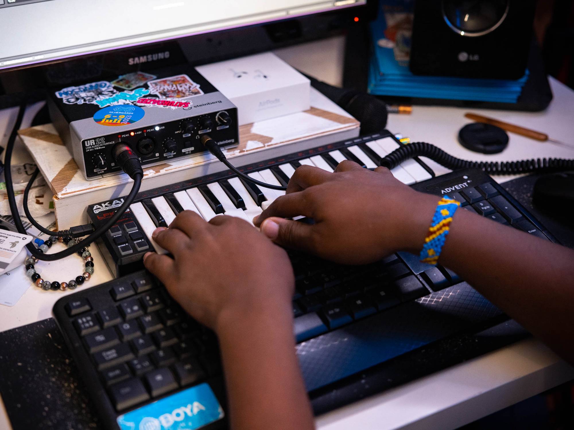 Lucien sine hender som spiller på et lite MIDI-keyboard koblet til PC-en hans.