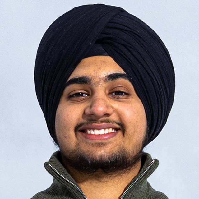 Et portrettfoto av Gurveer Singh. Han har litt skjegg, brune øyne og har på seg sort turban. Han smiler bredt til kamera.