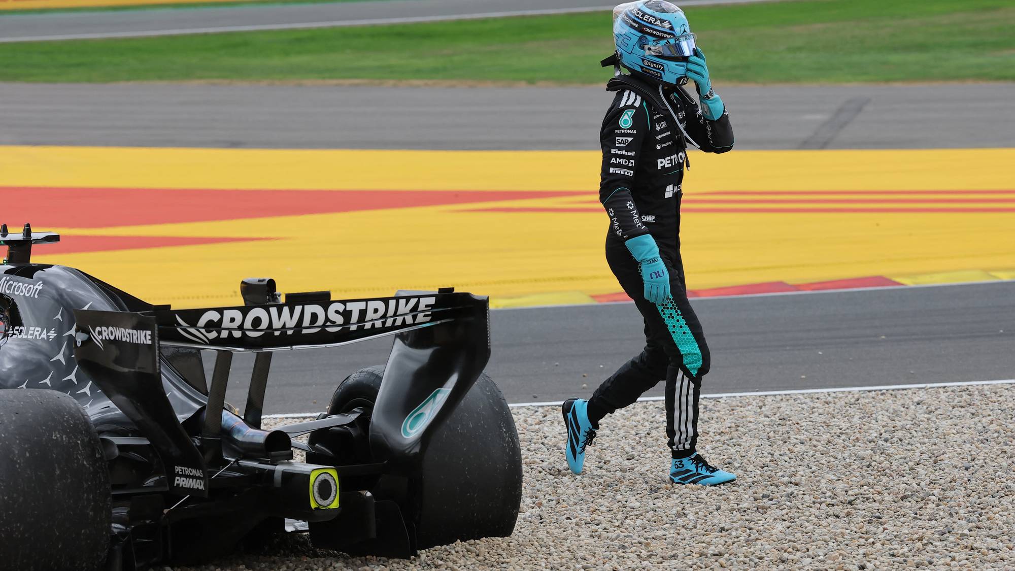 George Russell går bort fra sin parkerte Mercedes-formel 1-bil i grusfellen ved banekanten. (Bildebeskrivelsen er laget av en KI-tjeneste)
