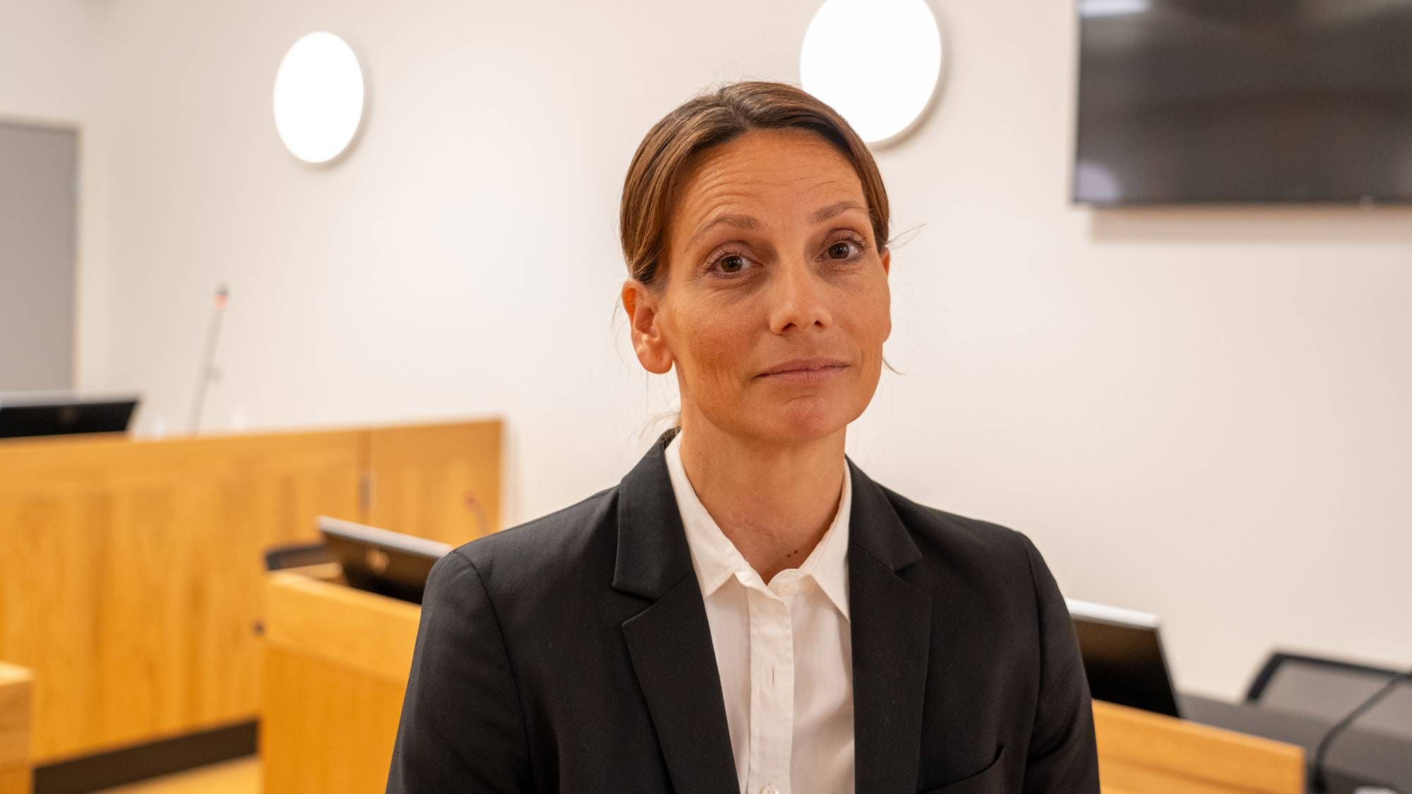 Kvinne i dressjakke i en rettssal. (Bildebeskrivelsen er laget av en KI-tjeneste)