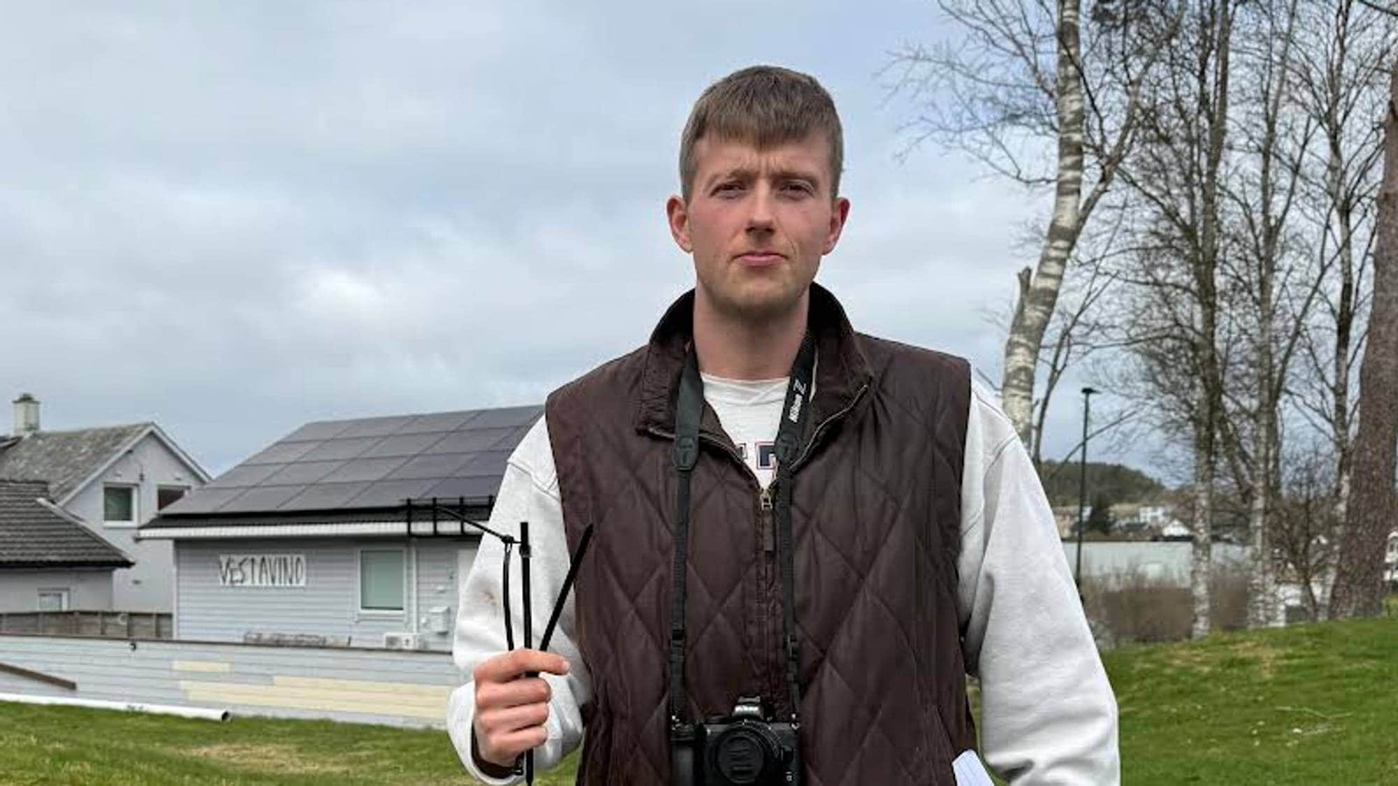 Morten Vågset Møller, journalist i Vestavind i Sveio, held tre plaststrips i handa. Han har brun boblevest og kamera rundt halsen, med grasbakke og hus i bakgrunnen.