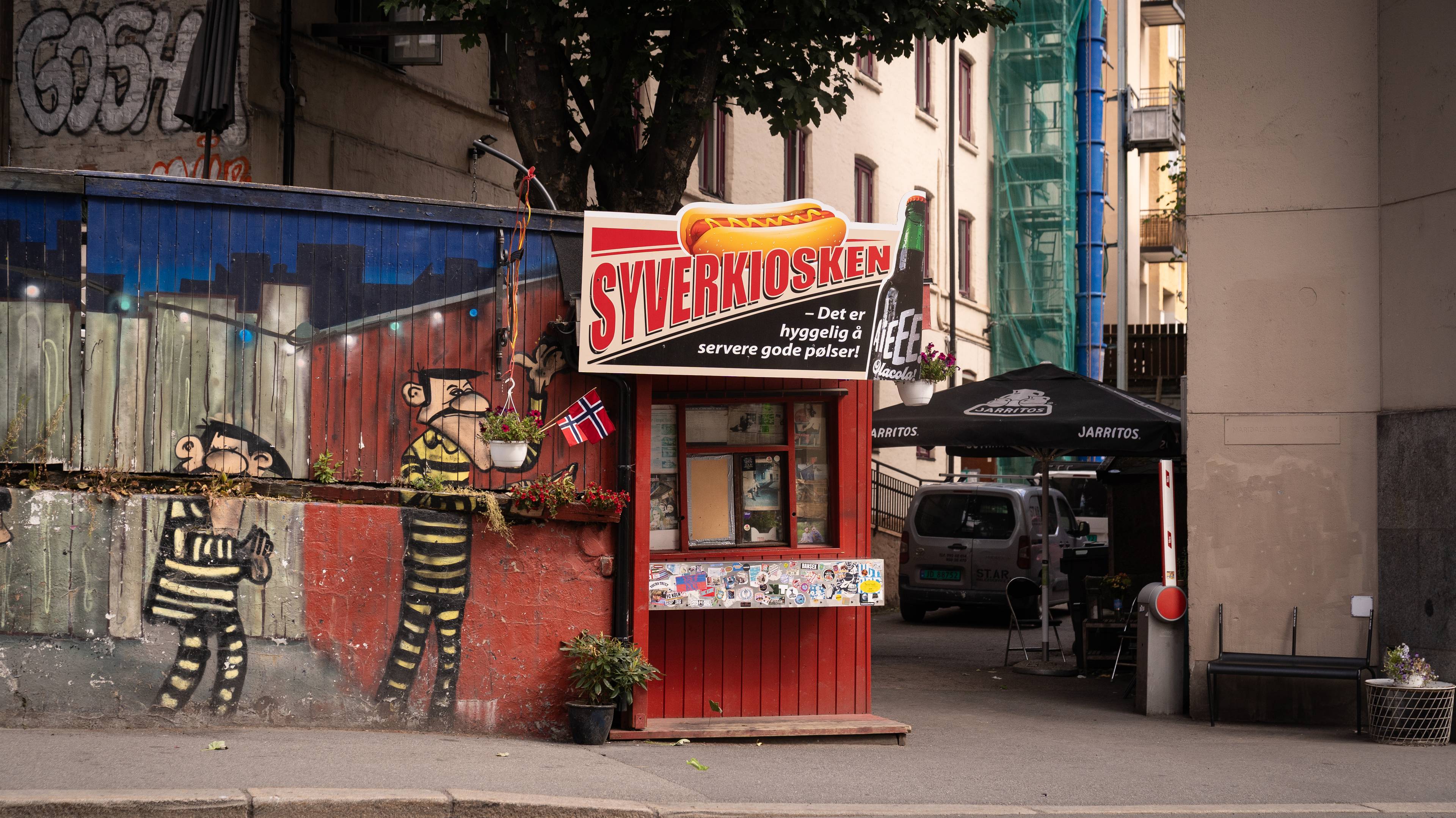En rød bygning med et skilt på der det står syverkiosken