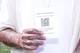 Javier Ernesto Auris Chavez / NRK Person med tatoverte hender holder et ark med informasjon om falske billetter og en QR-kode. (Bildebeskrivelsen er laget av en KI-tjeneste)