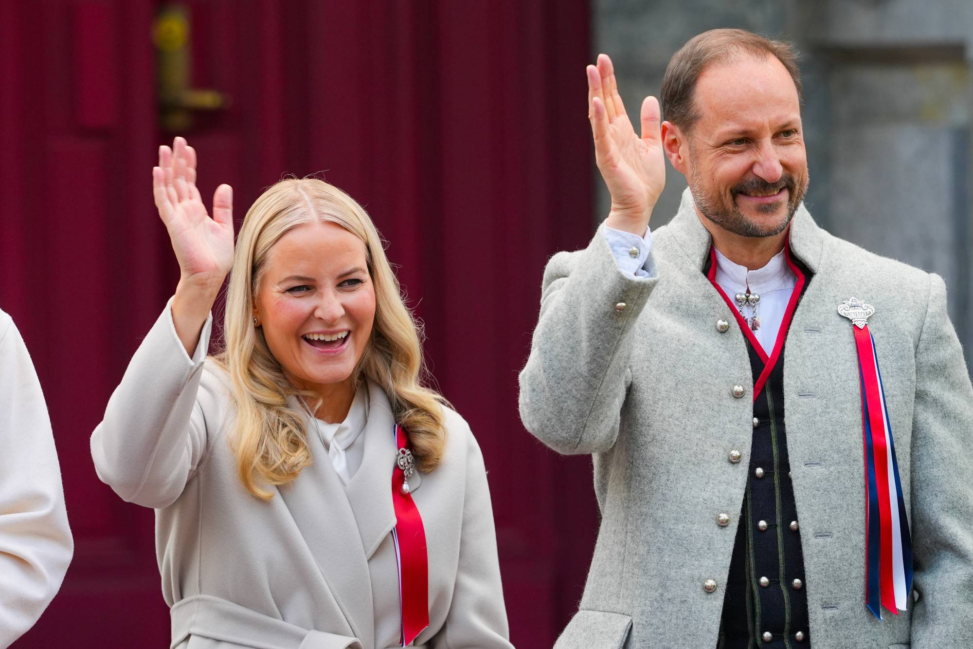 Kronprins Haakon og kronprinsesse Mette-Marit vinker til barnetoget på Skaugum
