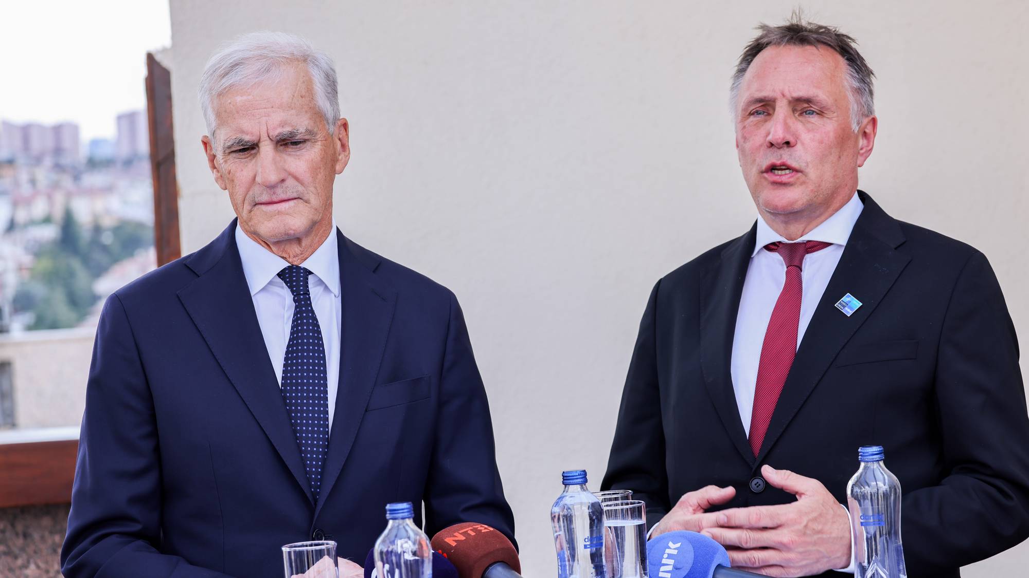 Jonas Gahr Støre og Tore Sandvik står ved en talerstol med mikrofoner.