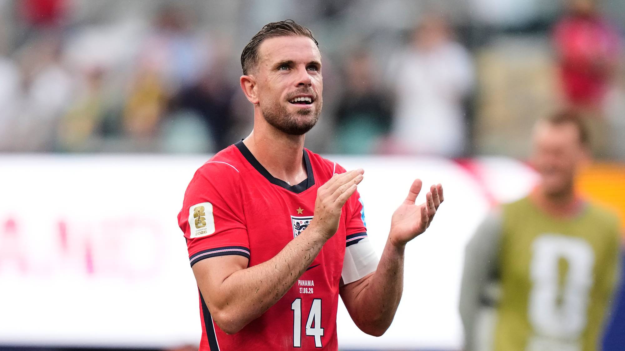 Jordan Henderson klapper til publikum under en fotballkamp i rød England-drakt. (Bildebeskrivelsen er laget av en KI-tjeneste)