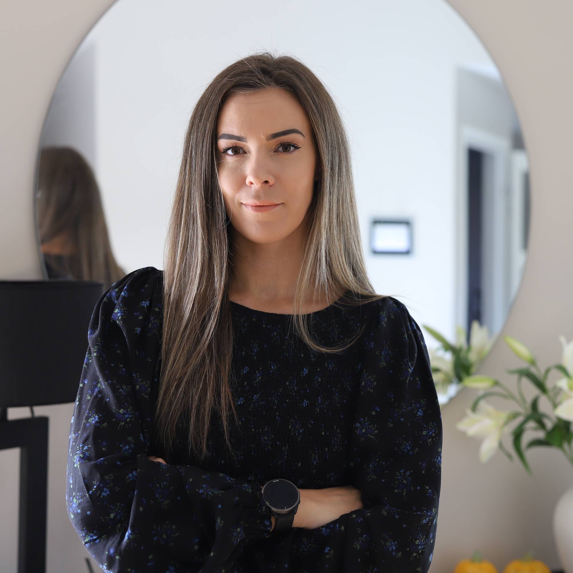 Sara Emilie Tandberg står med armene i kors hjemme i stua. 