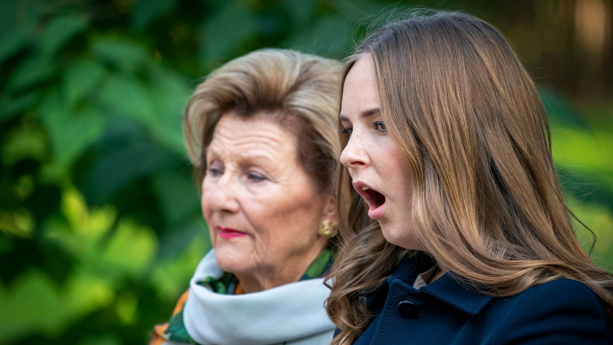 Dronning Sonja står i bakgrunnen. Foran står Ingrid Alexandra som gjesper. 