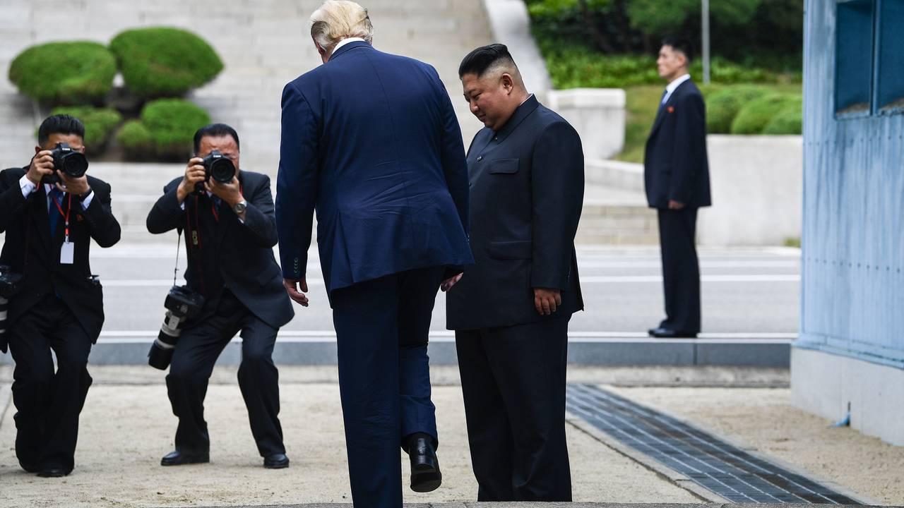 USAs president Donald Trump i det han skal sette foten ned på nordkoreansk jord med Kim Jong-un