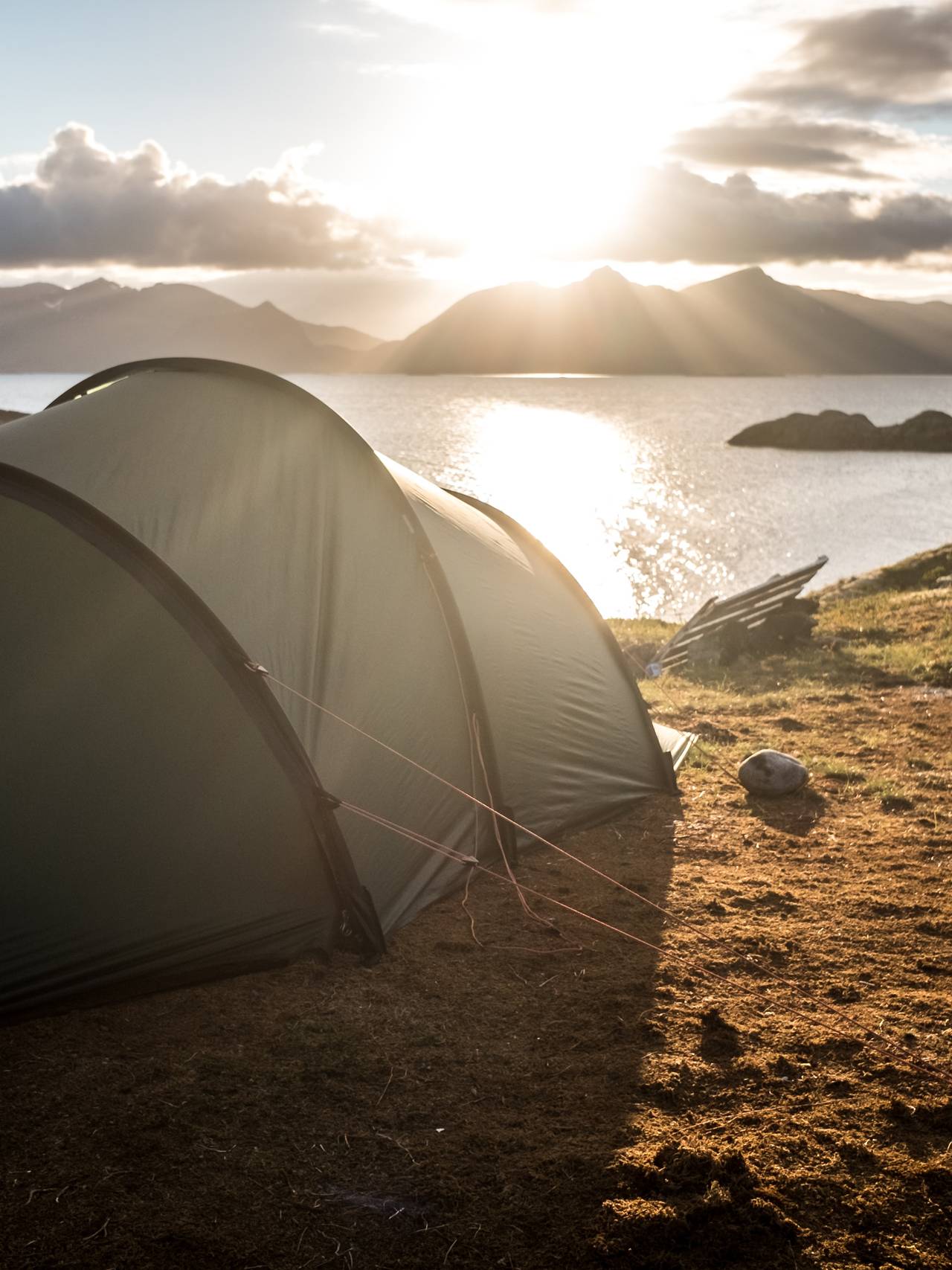 Telt i Lofoten sol i bakgrunn.