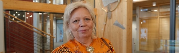 en person i kofte med en oransje silkesjal 