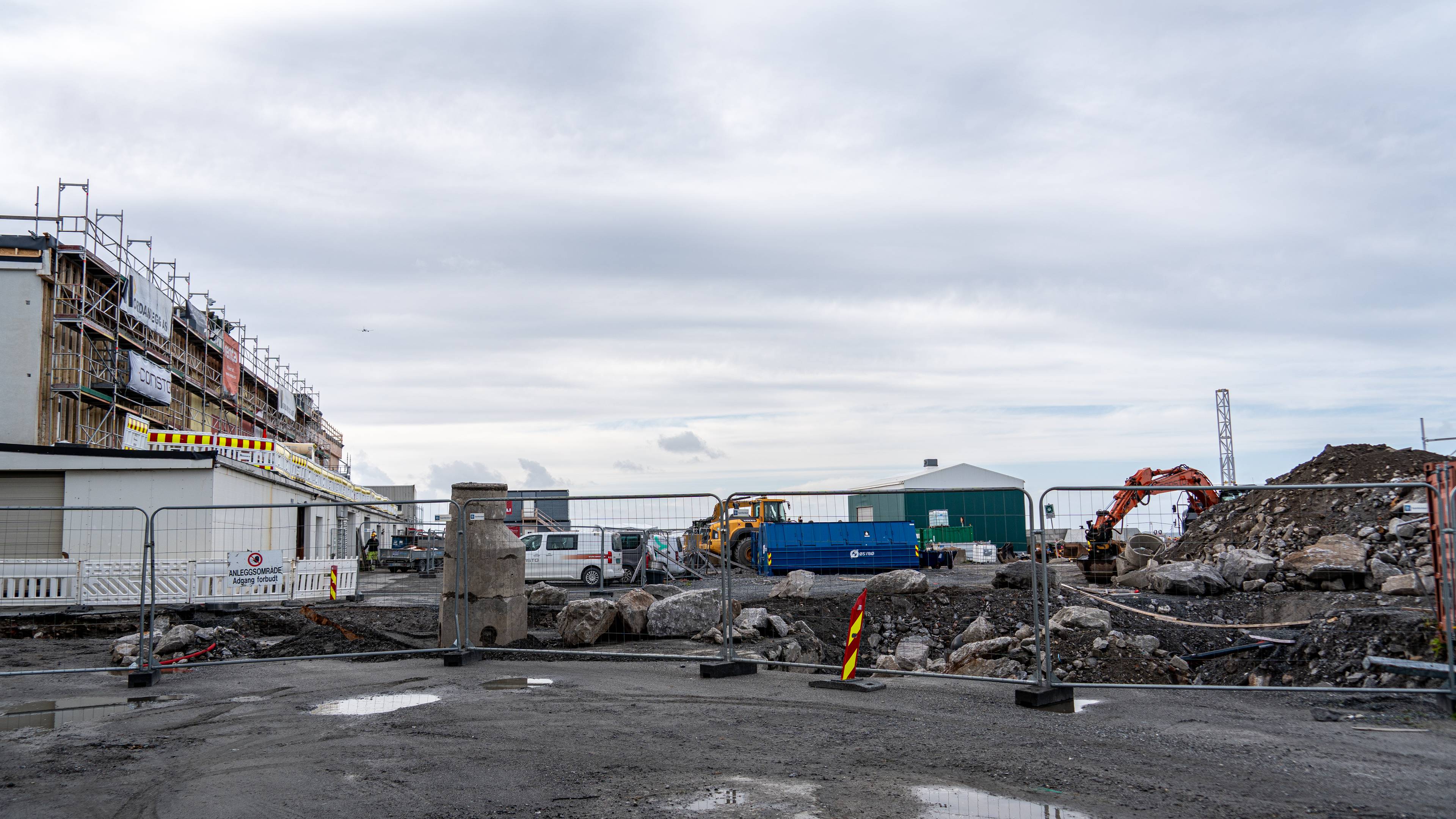 Green H bygger ny hydrogenfabrikk på Langstranda i Bodø. På bildet ser vi et inngjerdet områd som er gravd opp, ved siden av grusveien og hauger med grus og stein.