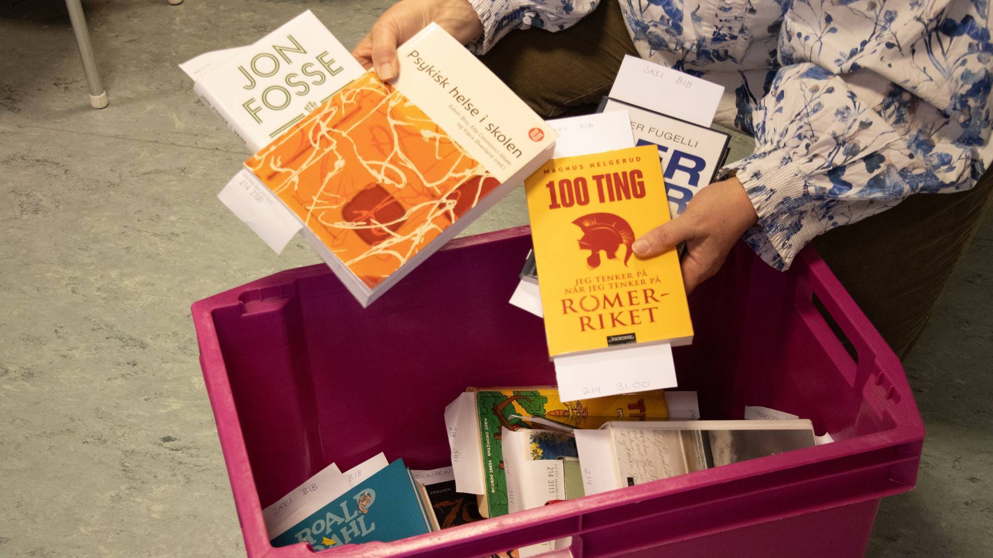 Bibliotekssjefen i Førde gjer bøker klar til transport.