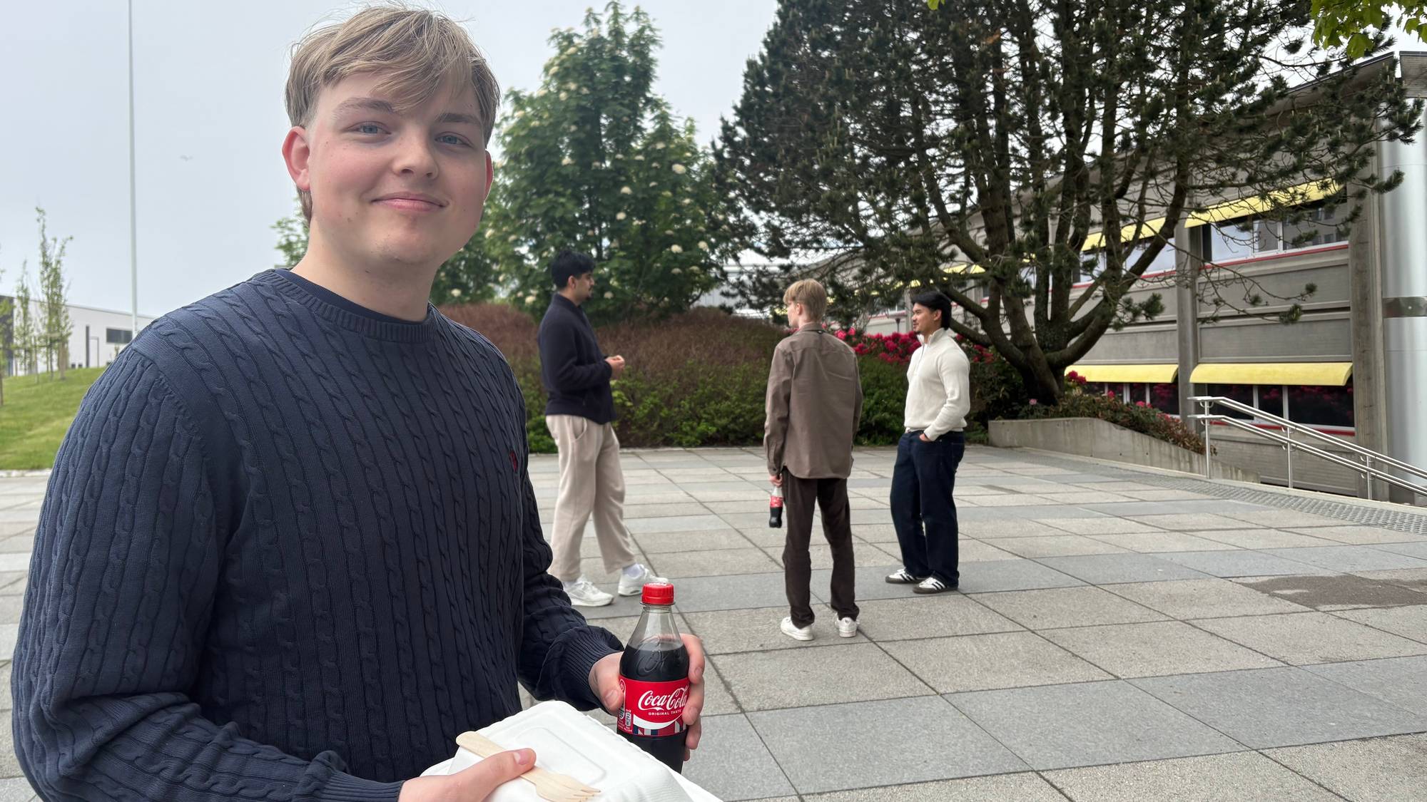 Student som står på en åpen plass. 
