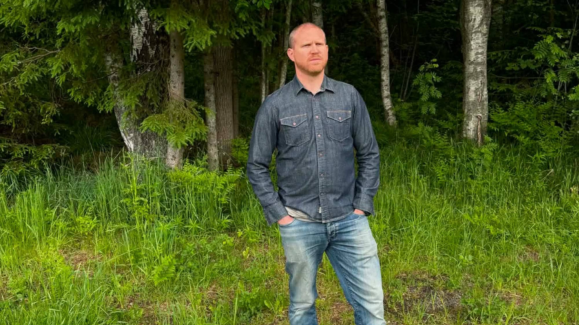 En mann står oppstilt i et skogområde