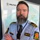 Politiet En mann i politiuniform ser i kamera. Han har stort skjegg og ser alvorlig ut.