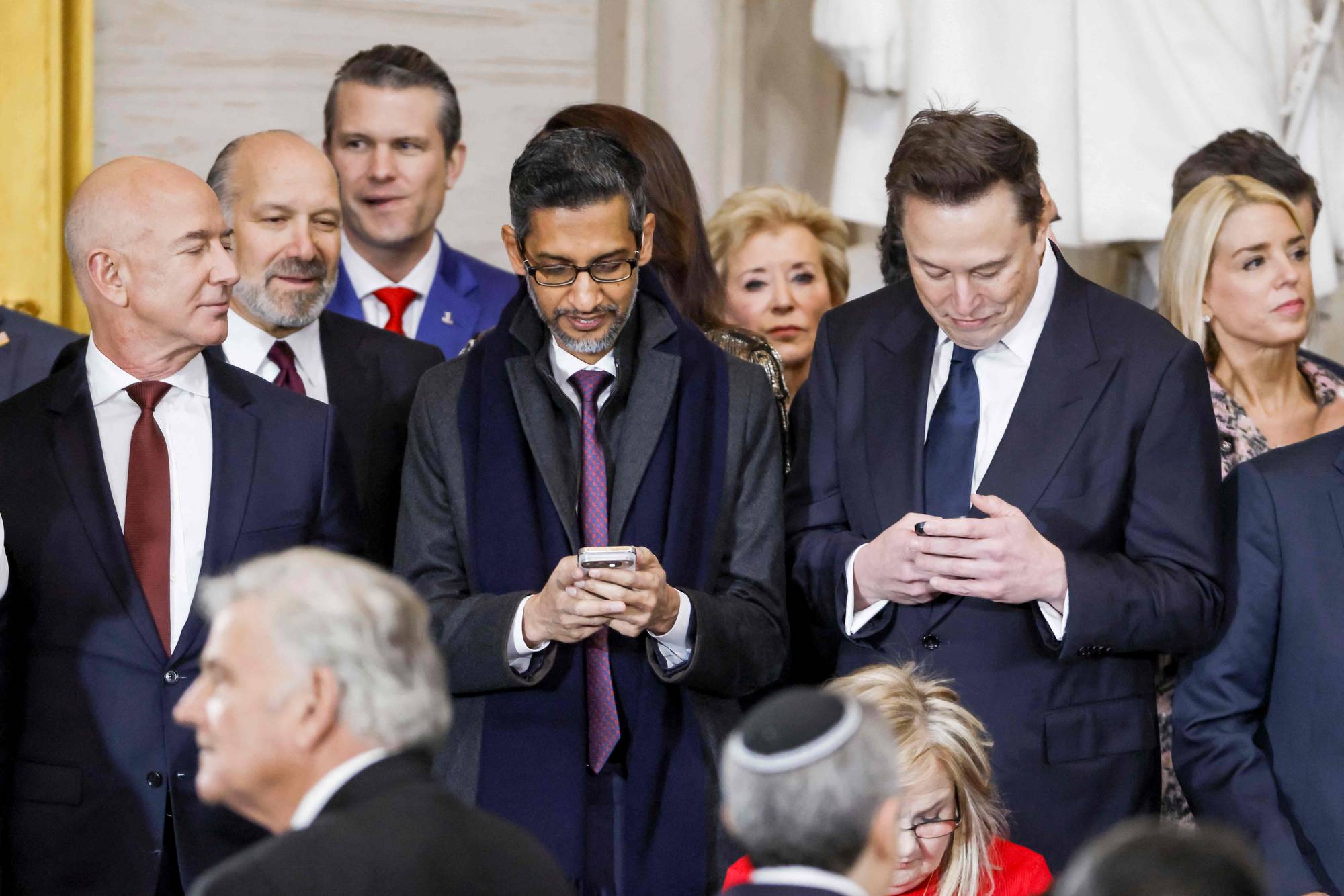 Googlesjefen Sundar Pichai er på telefonen. Han står i midten mellom Jeff Bezoz og Elon Musk.