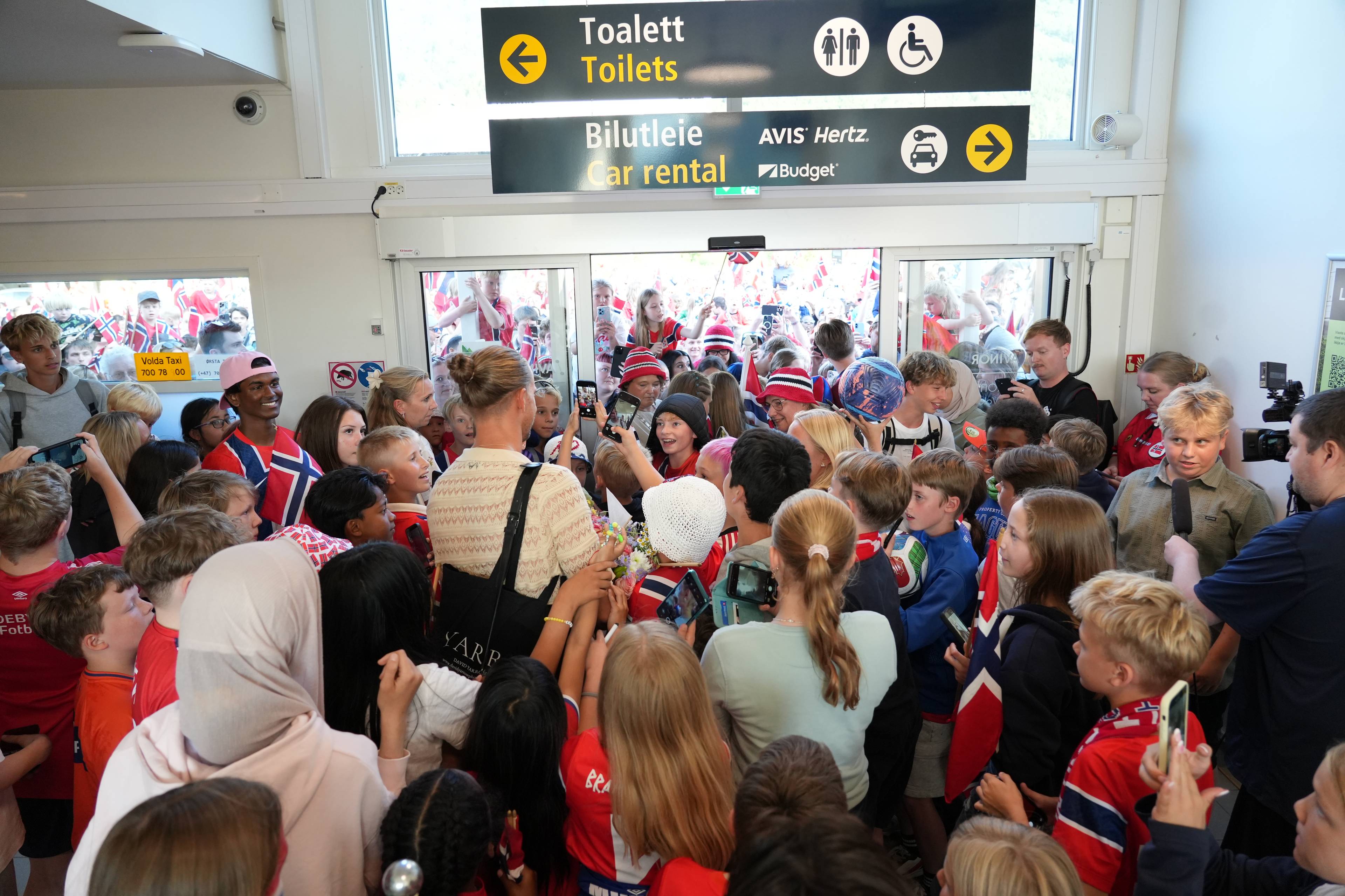Eit hav av unge som ville ha autografar og bilete møtte landslagskeeperen då han landa på Ørsta-Volda lufthamn tysdag kveld.