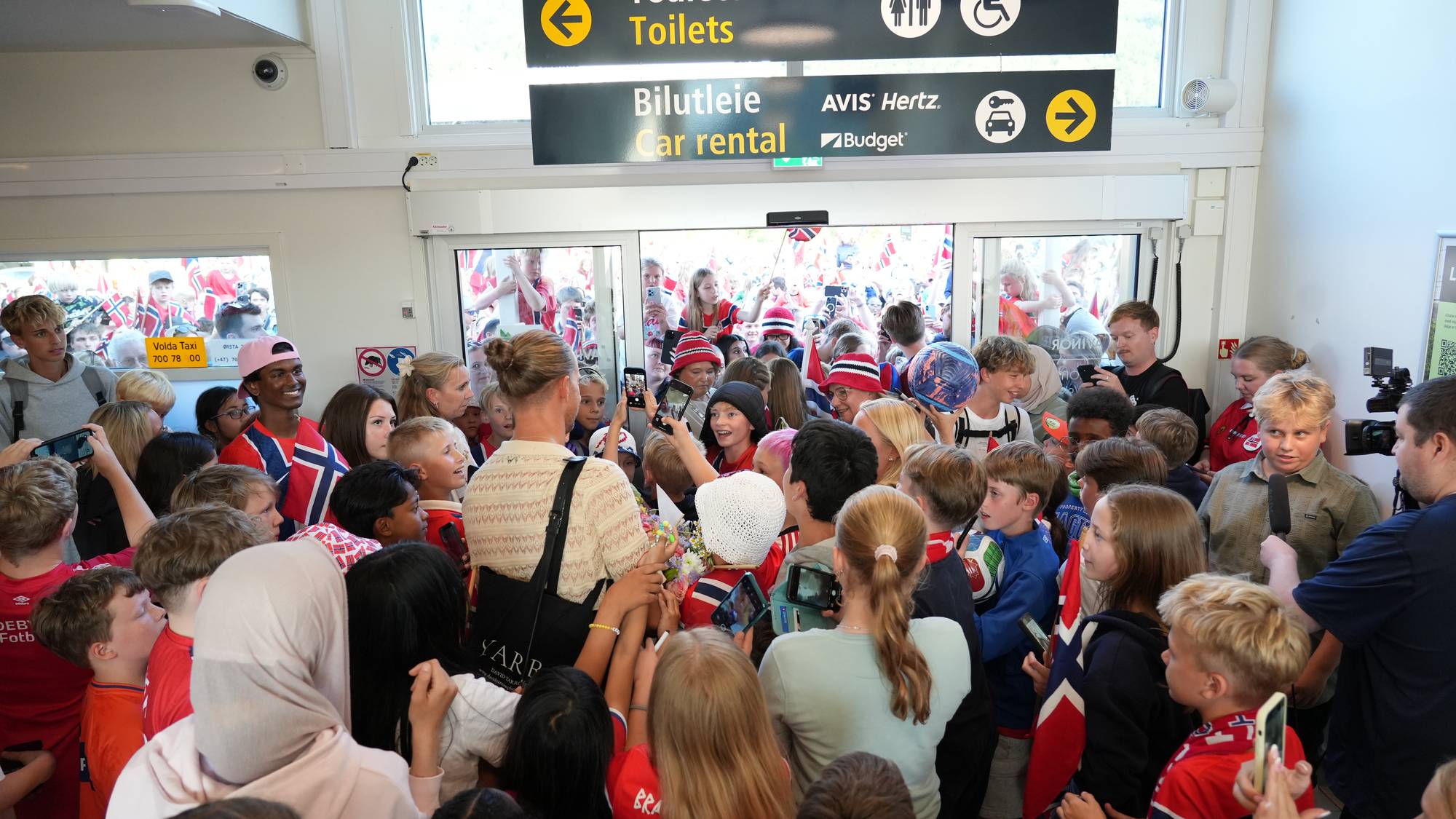 Eit hav av unge som ville ha autografar og bilete møtte landslagskeeperen då han landa på Ørsta-Volda lufthamn tysdag kveld.