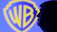 Dado Ruvic / Reuters / NTB En person står med ryggen til foran en stor logo av Warner Bros på en blå bakgrunn. Bildet fanger konturen av personen mot den lyse logoen, og fremhever samarbeidet med selskapet. Omgivelsene er dominert av det blå lyset fra skjermens bakgrunn. Det er uklart hvor bildet er tatt, men det gir et inntrykk av en pressevisning eller lansering. (Bildebeskrivelsen er laget av en KI-tjeneste)