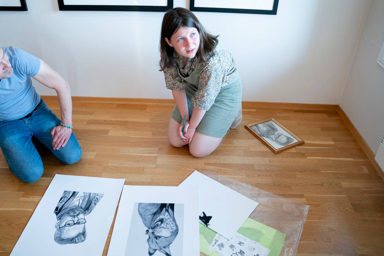 Maud Angelica Behn signerer tegningen hun lagde av sin far Ari Behn under en presentasjon av utstilling med Ari Behns verker på Galleri Varden på Jeløya. Gallerist Kenneth Stensholt t.v.